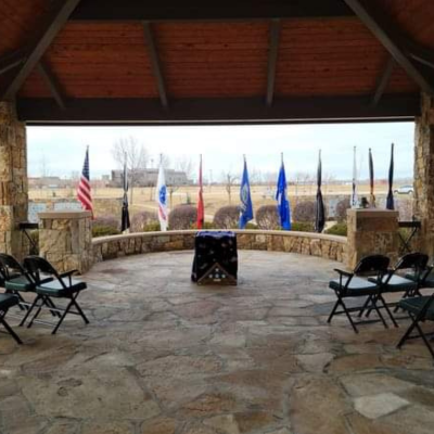 View of the ceremony location with black folding chairs and a podium.